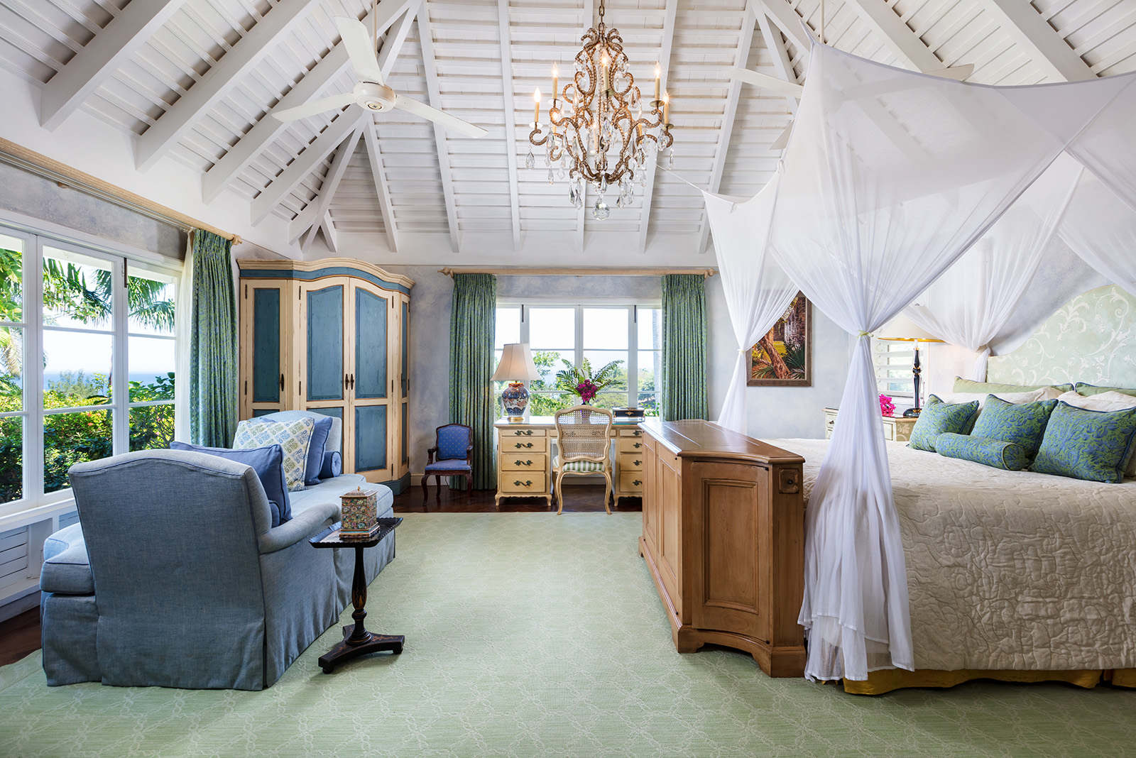 Little Hill villa bedroom with four-poster bed and a blue sofa