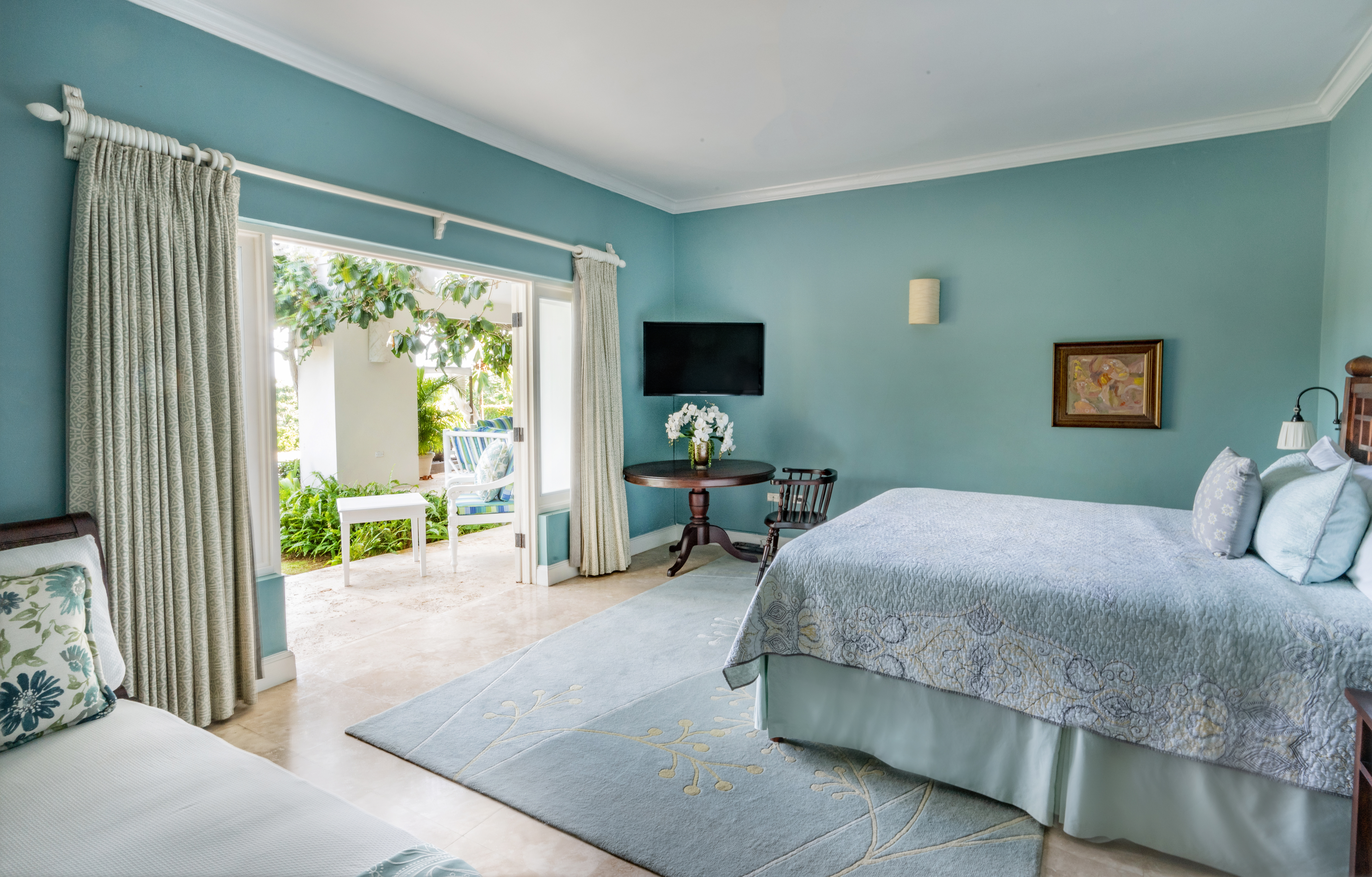 Hanover Windward Gardens bedroom with bed, table and TV