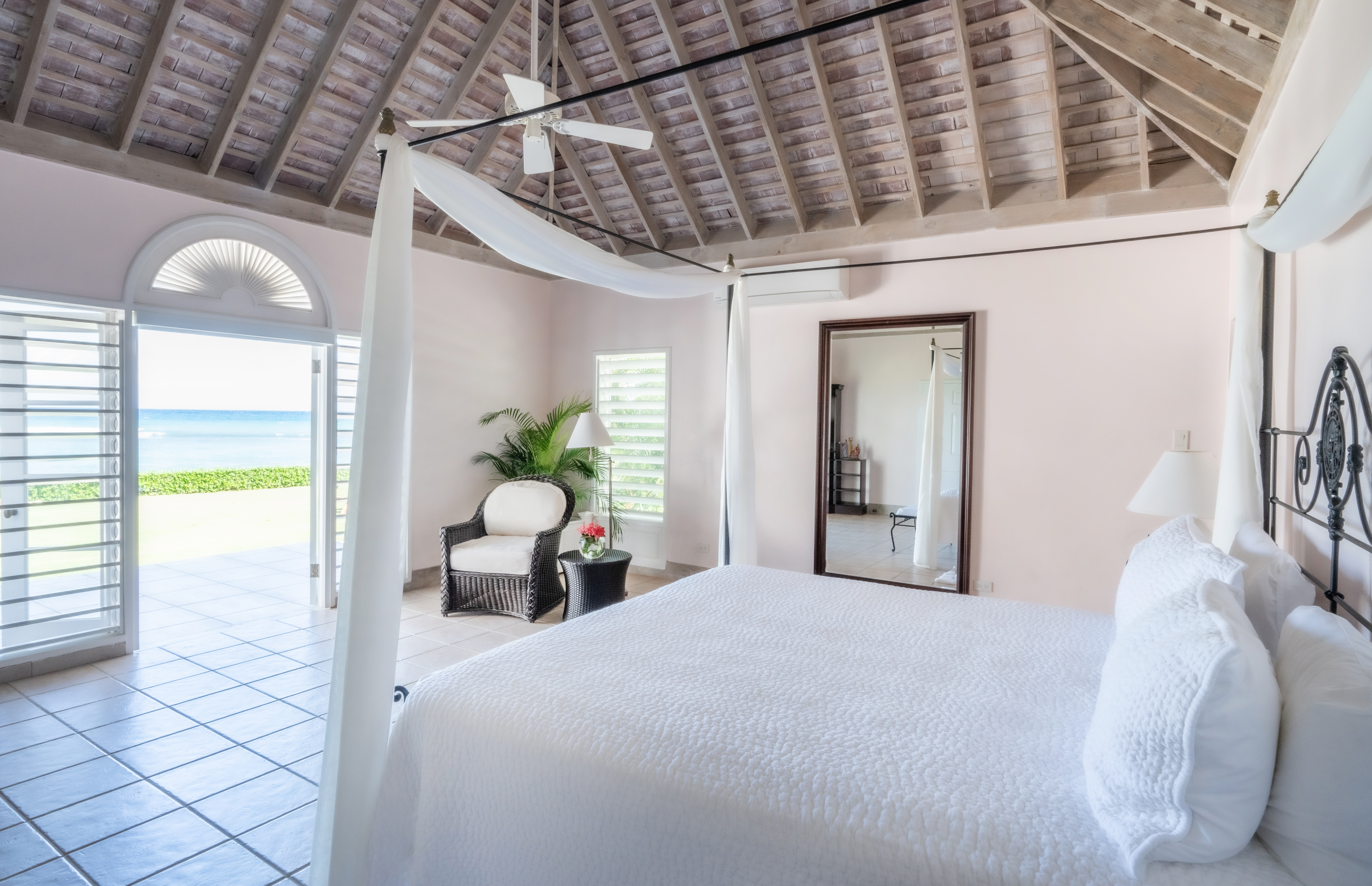 Phoenix villa bedroom with open doors leading to Caribbean Sea