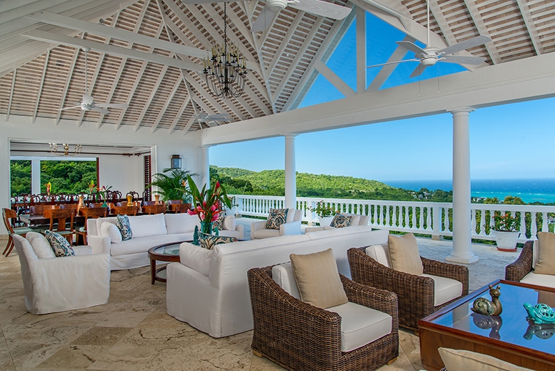 Villa Amana patio with sofas and chairs and view of the Caribbean Sea