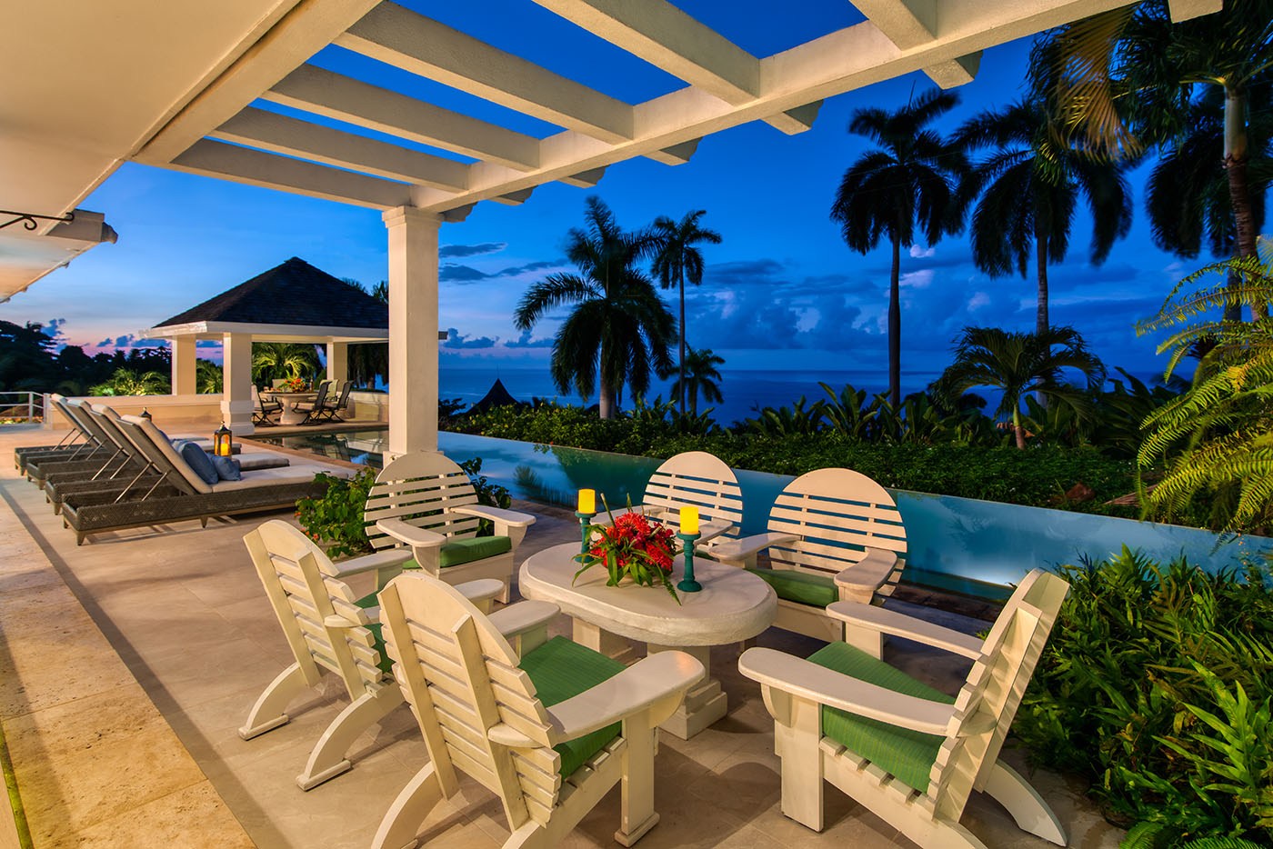 Trinity Villa seating area next to Caribbean Sea at dusk